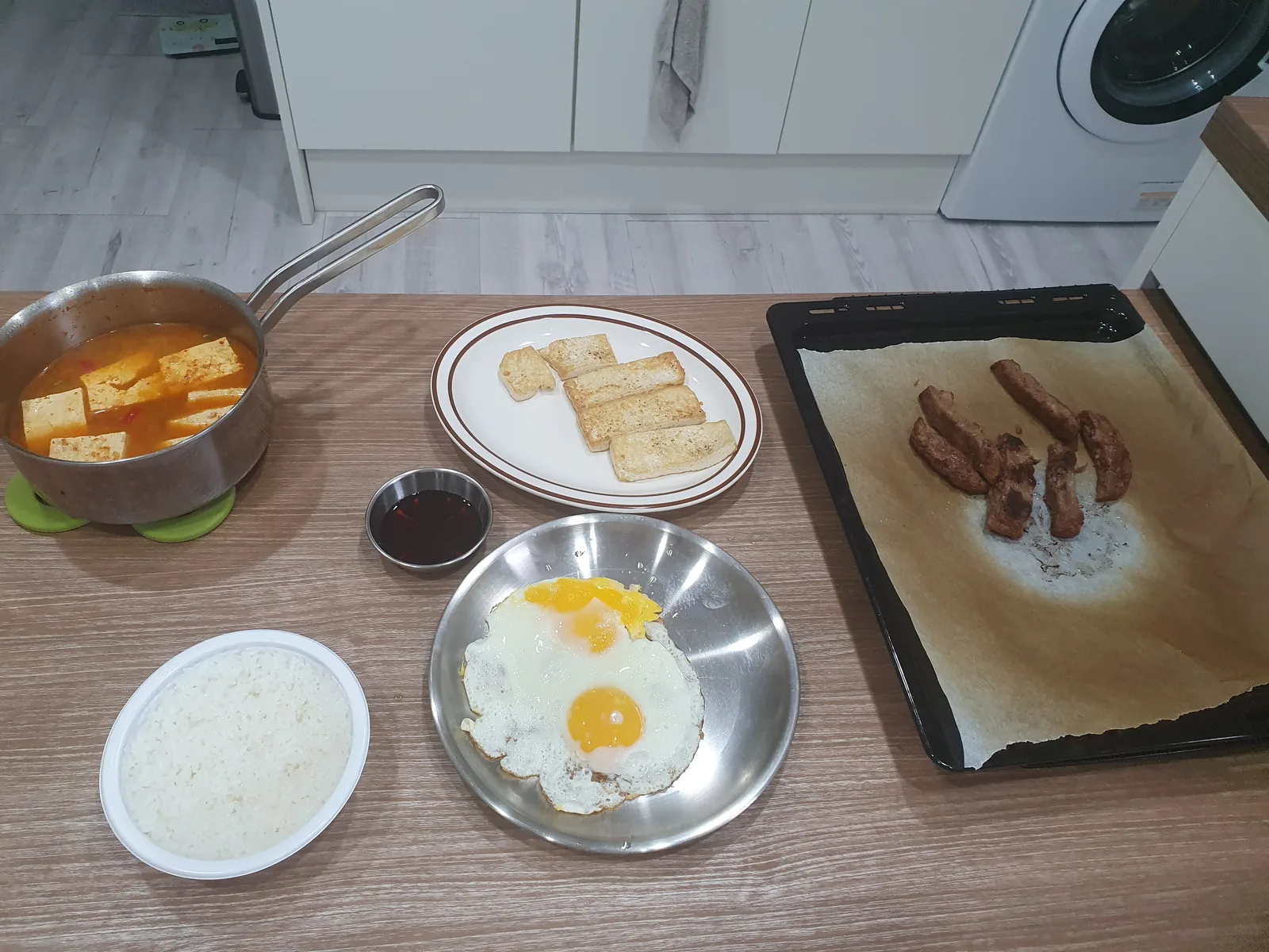 A table set with gochujang stew and side dishes