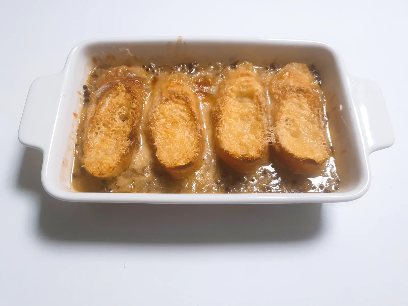 French onion soup topped with baguette and cheese
