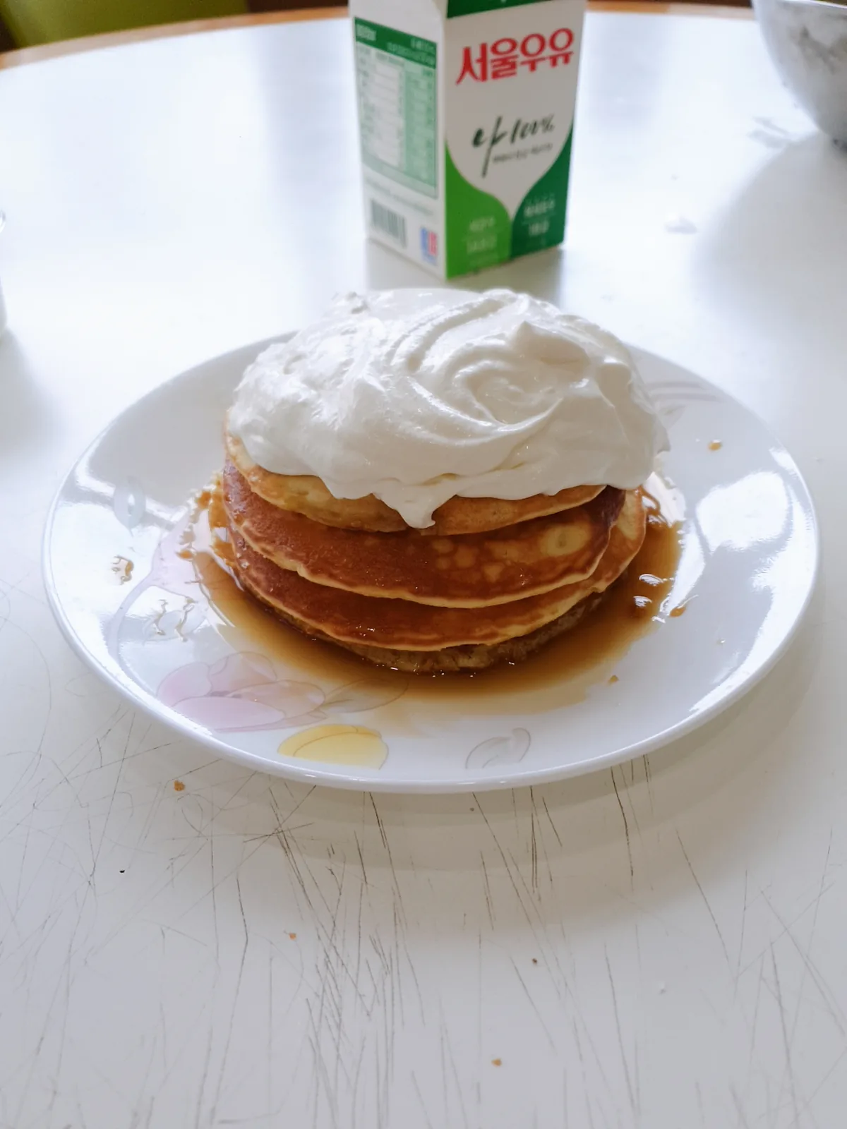 A stack of pancakes topped with cream