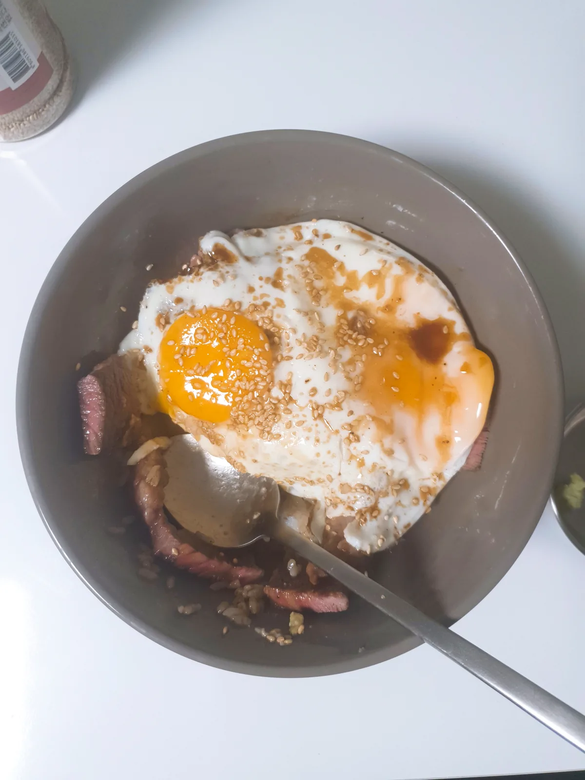 A rice bowl topped with steak and an egg