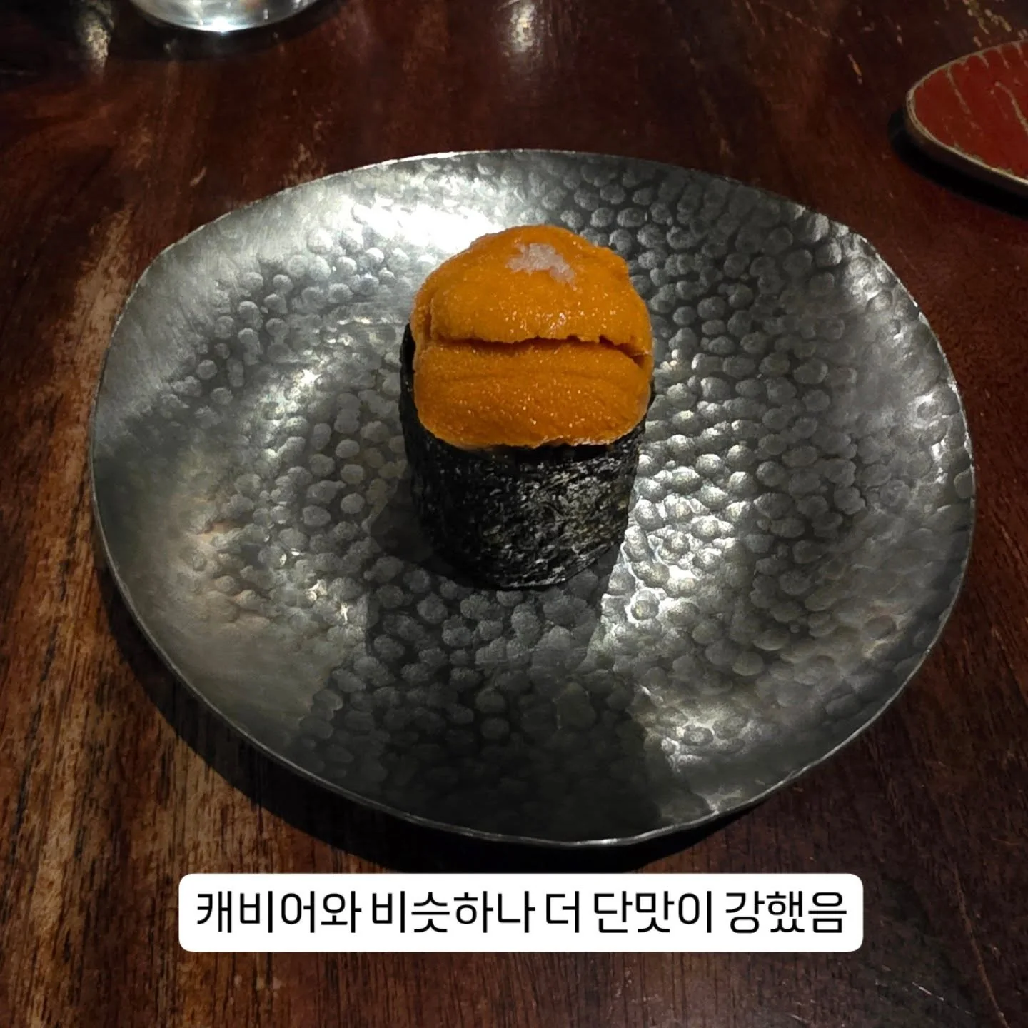 A small orange-topped course on a dark plate