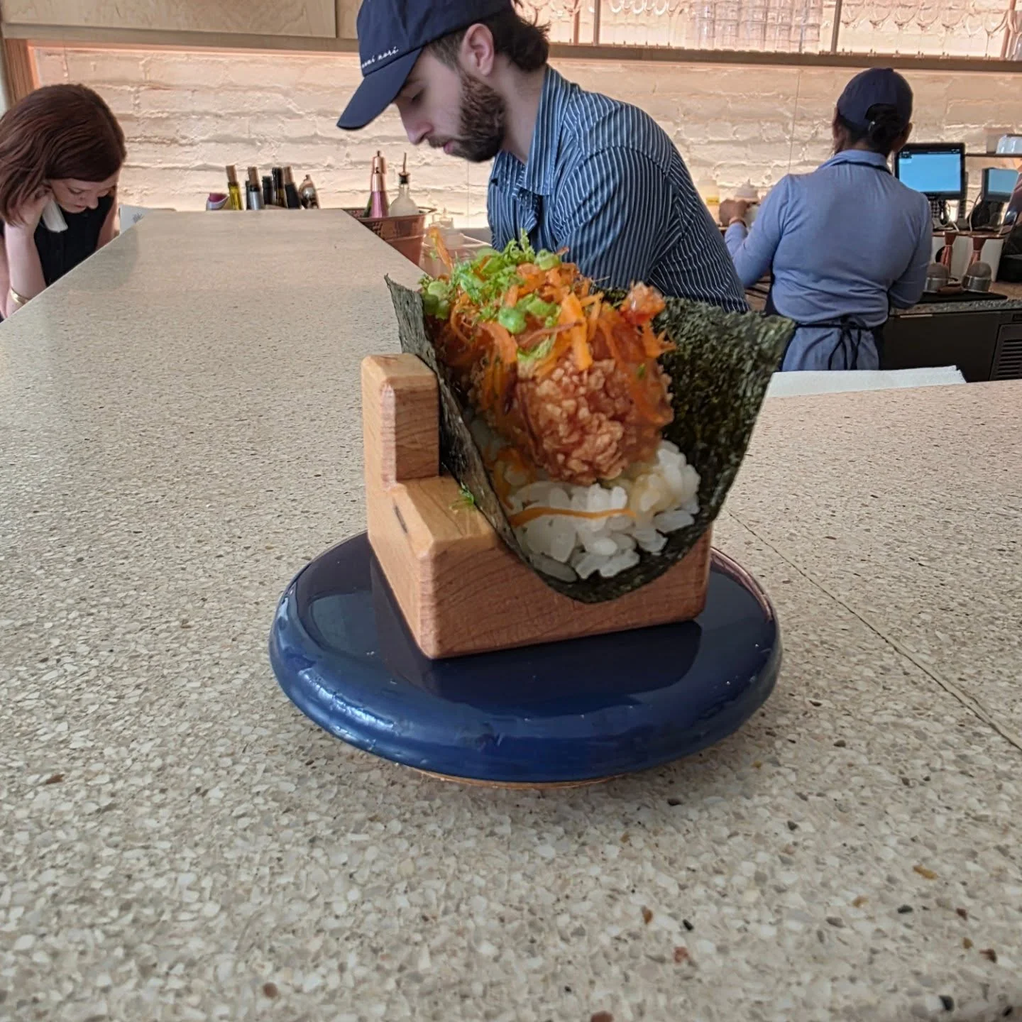 A second temaki hand roll on a blue plate