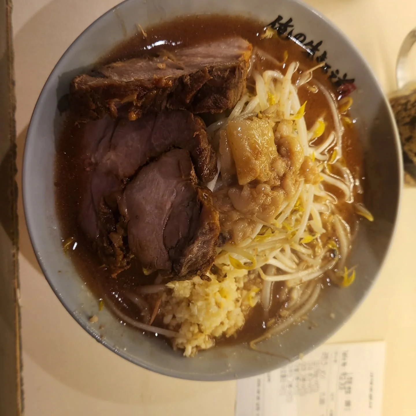 A bowl of Jiro-style ramen topped with pork and bean sprouts