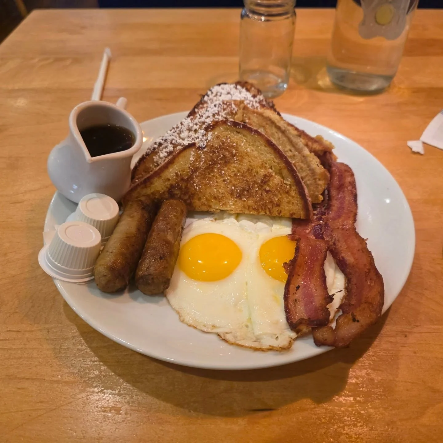 Eggs, bacon, sausage, French toast, and fruit at Yolk